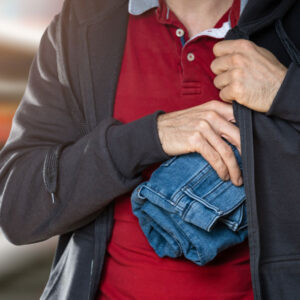 man hiding folded jeans in jacket